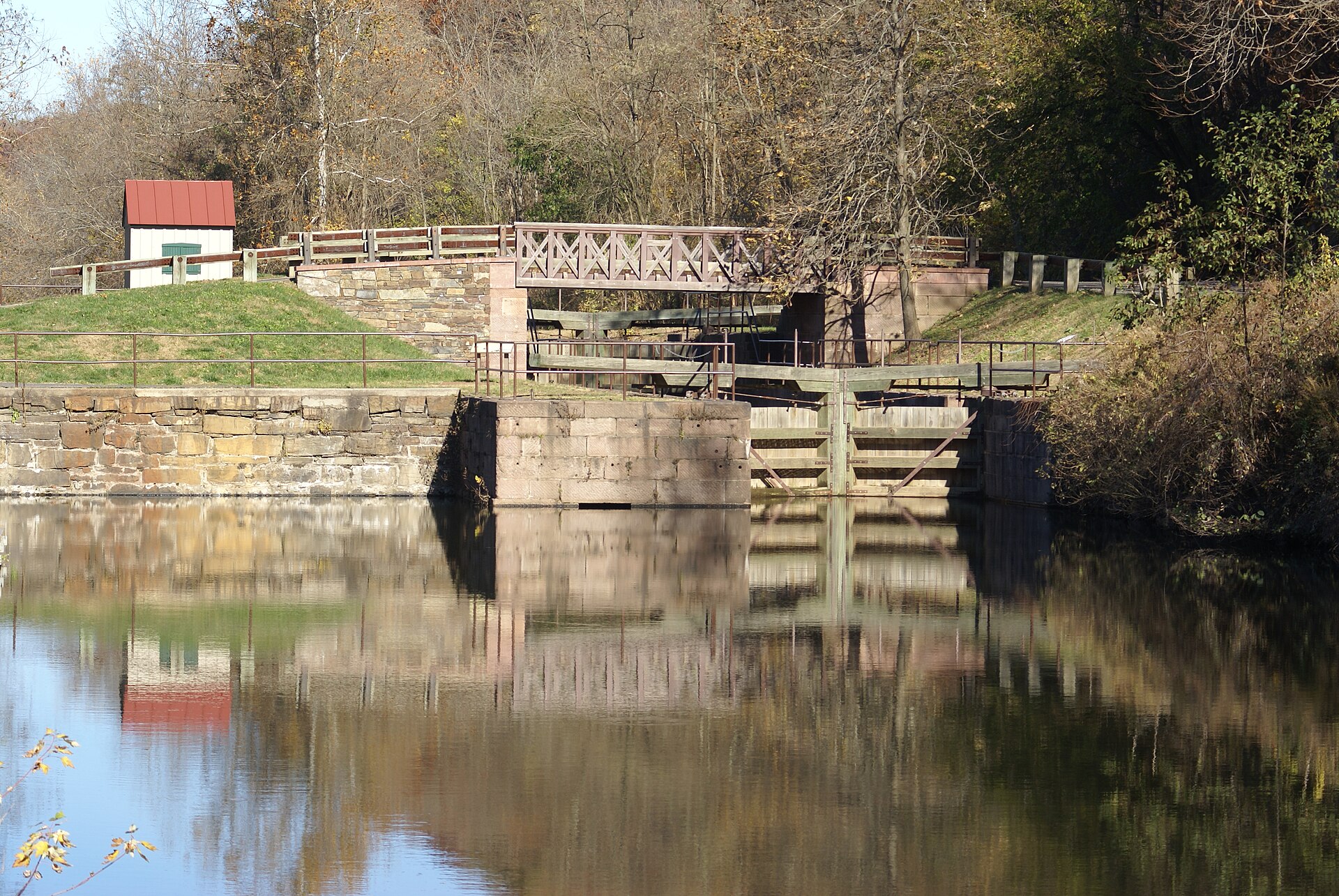 Weathered 1820s stone masonry of the Lock 60 spillway arch over rushing water