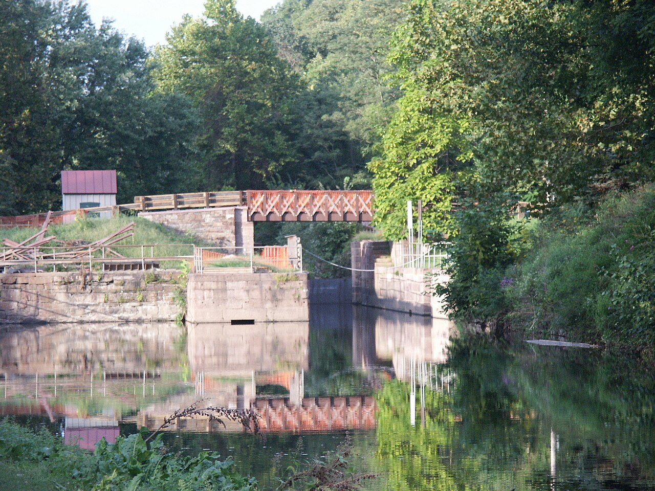 Lock 60's stone chamber, wooden gates and the Lockhouse with its red roof in summer