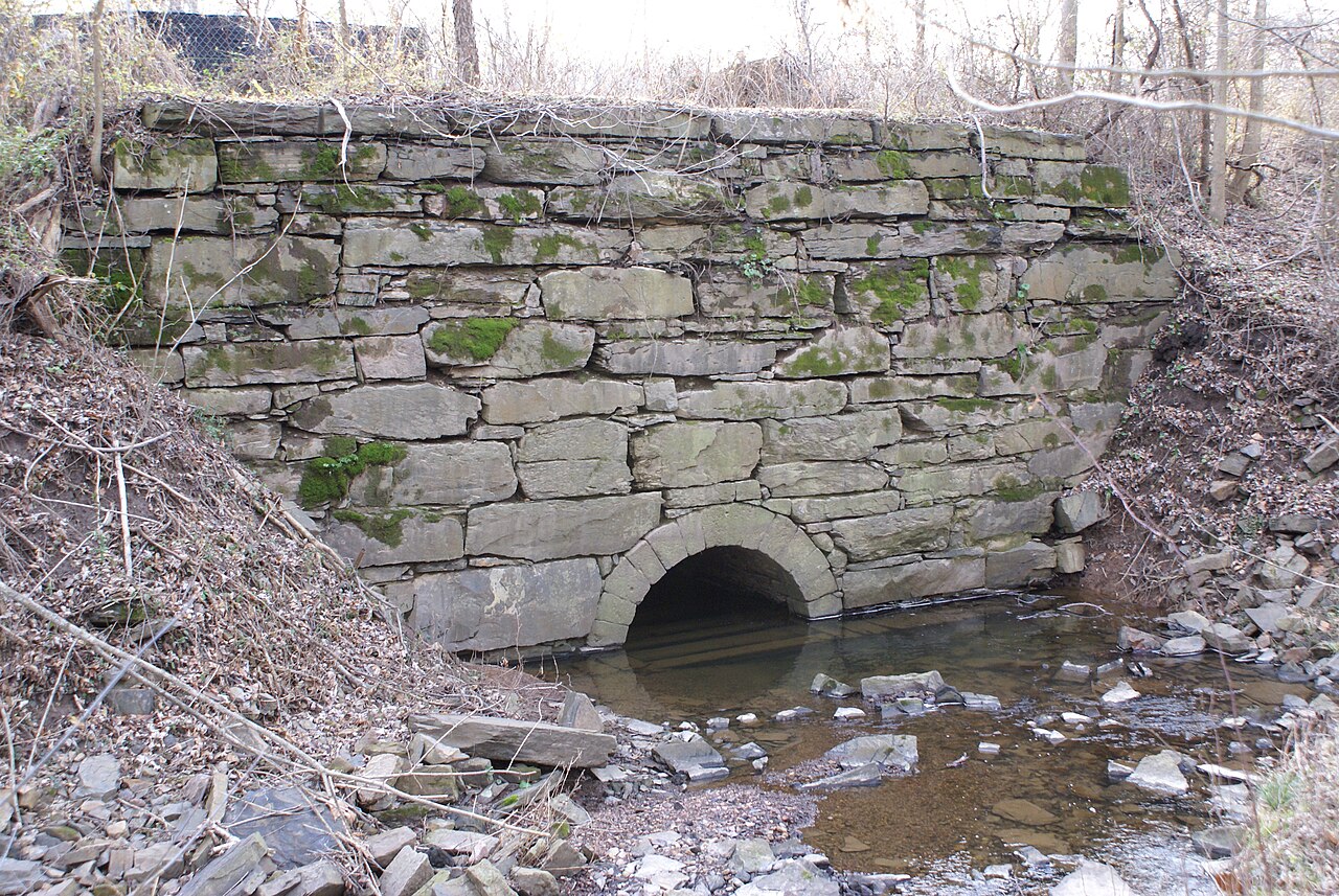 The narrow, tree-lined Oakes Reach canal beside its towpath near the Oaks viaduct